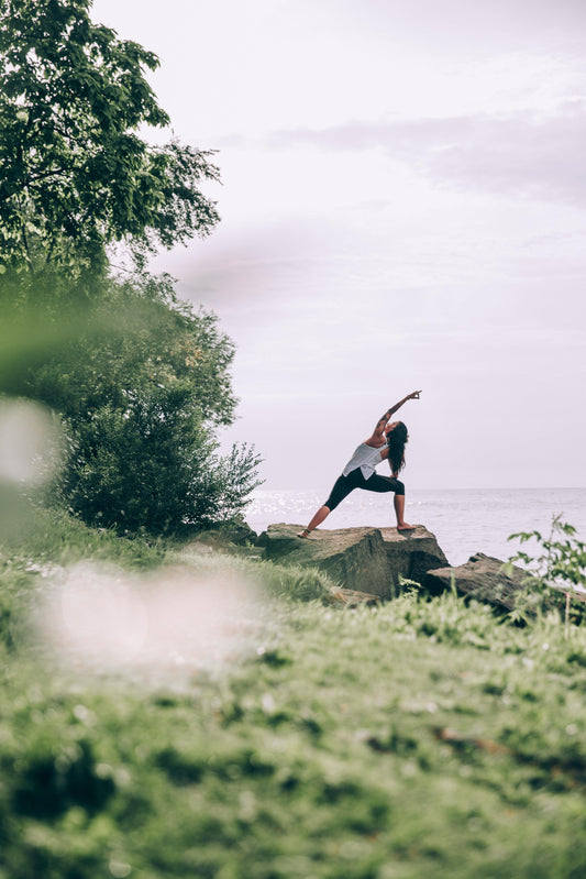 woman-reaching-yoga-pose-in-nature-trikasana-triangle-pose