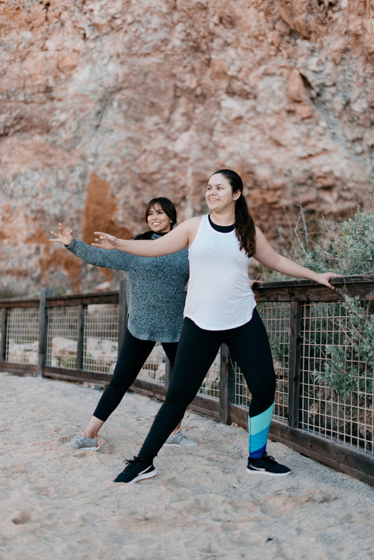 two-women-strike-a-yoga-pose-on-the-beach