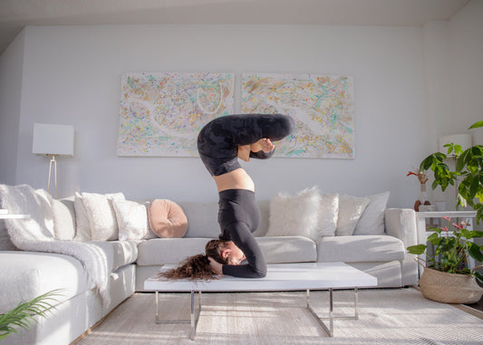 woman-practices-advanced-yoga-pose-on-coffee-table