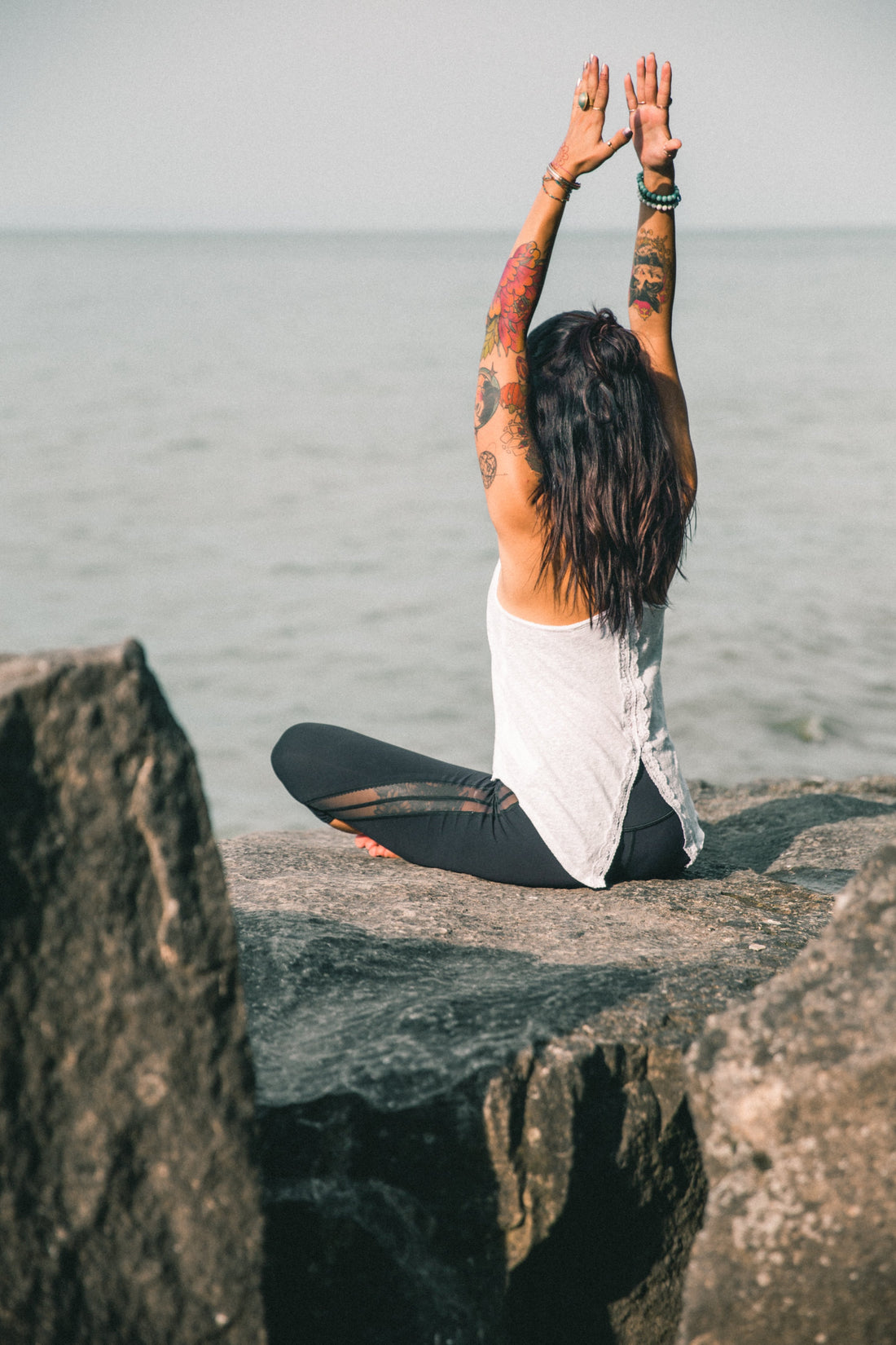 tattooed-woman-doing-yoga-pose-on-the-beach