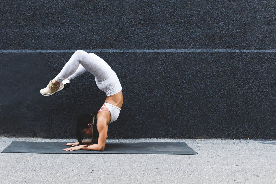 young-woman-doing-yoga-pose-against-black-wall