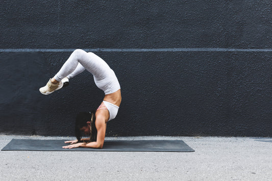 woman on yoga mat making standing yoga pose
