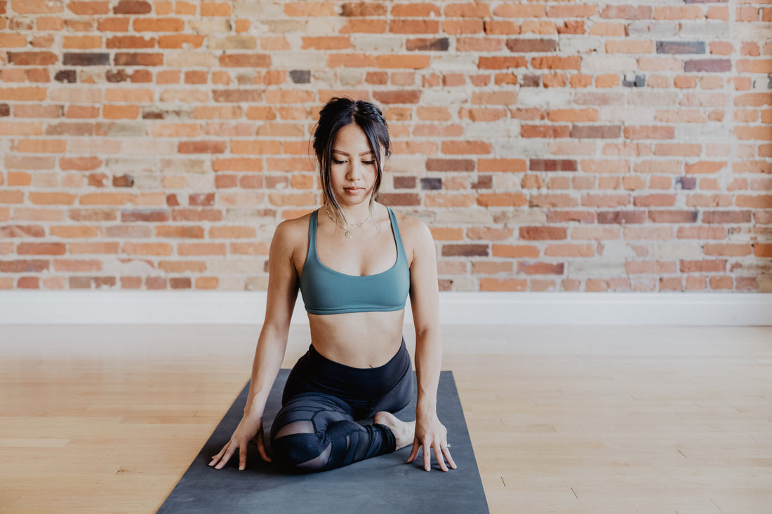 young-woman-in-yoga-pose-against-exposed-brick